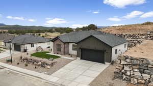 Ranch-style house with a garage, a mountain view, a shingled roof, and concrete driveway