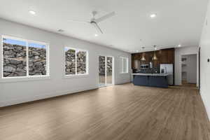 Unfurnished living room featuring baseboards, a ceiling fan, recessed lighting