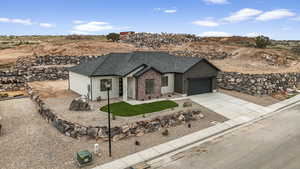 Ranch-style home featuring an attached garage, a shingled roof, a front lawn, brick siding, and concrete driveway