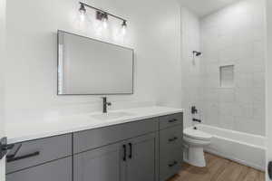 Full bath featuring vanity, shower / tub combination, wood finished floors, and toilet