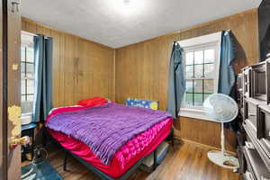 Bedroom featuring wooden walls and hardwood / wood-style flooring