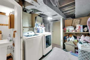 Clothes washing area with laundry area, a sink, washing machine and dryer, and visible vents