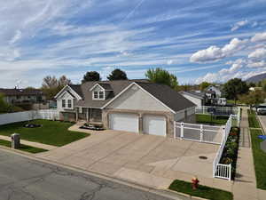 View of front of house with brick siding, fence, and a garage