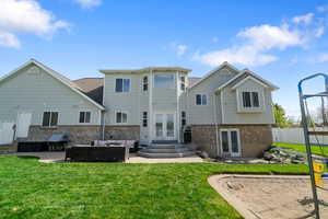Rear view of property with french doors, an outdoor hangout area, brick siding, entry steps, and a lawn