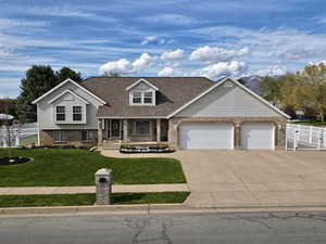 Tri-level home with fence, a front yard, brick siding, an attached garage, and driveway