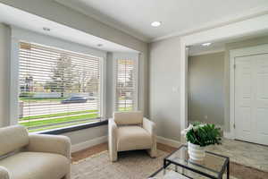 Sitting room with crown molding, recessed lighting, baseboards, and carpet