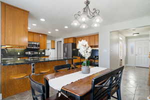Dining room featuring recessed lighting, light tile patterned flooring, and a notable chandelier