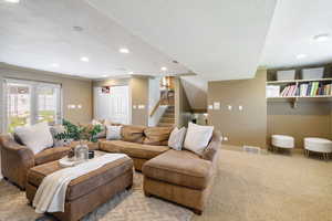 Living room with crown molding, recessed lighting, a textured ceiling, and visible vents
