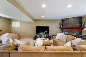 Living room with crown molding, recessed lighting, baseboards, and a large fireplace