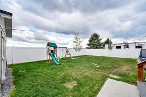View of yard with a fenced backyard and a playground
