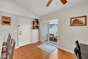 Entrance foyer featuring a ceiling fan, baseboards, wood finished floors, vaulted ceiling, and visible vents