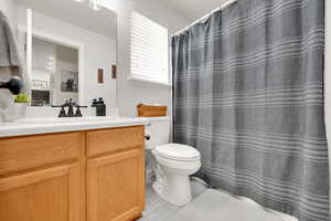 Main Bathroom with vanity, tile patterned floors, and toilet