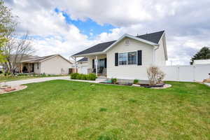 Ranch-style home featuring driveway, fence, a gate, and a front yard