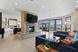 Living area with recessed lighting, light wood-style floors, and a fireplace