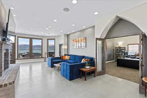 Living room featuring a brick fireplace, recessed lighting, plenty of natural light, and light wood finished floors