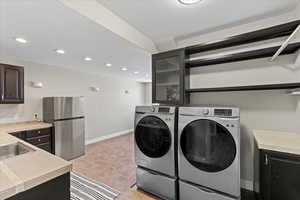 Washroom with recessed lighting, laundry area, light carpet, and baseboards