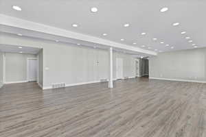 Below grade area featuring visible vents, recessed lighting, baseboards, and light wood-type flooring