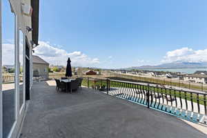 View of patio with outdoor dining area, a mountain view, a fenced backyard, and a pool
