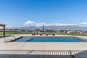 View of swimming pool with a fenced in pool, a mountain view, a patio, and fence