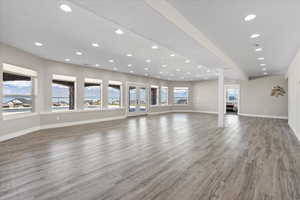 Unfurnished living room featuring recessed lighting, baseboards, and wood finished floors