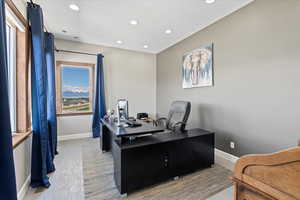 Home office with light wood-style floors, baseboards, and recessed lighting