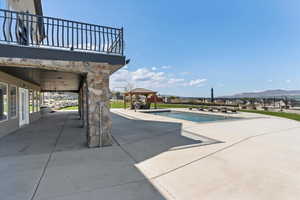 Outdoor pool with a mountain view, a gazebo, and a patio area