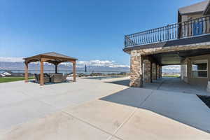 View of patio with a ceiling fan, a gazebo, a mountain view, a balcony, and outdoor lounge area