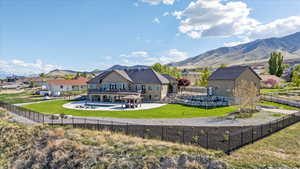 Back of property with a residential view, a fenced backyard, a fenced in pool, a mountain view, and a patio