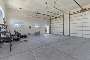 Garage featuring a wall mounted air conditioner and electric panel
