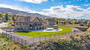 Back of property with a gazebo, a fenced backyard, a lawn, and a residential view