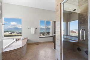 Bathroom with a shower stall, a healthy amount of sunlight, and tile patterned flooring