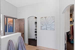 Bedroom featuring arched walkways and a spacious closet
