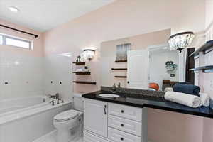 Ensuite bathroom with a bath, vanity, tile patterned floors, toilet, and ensuite bath