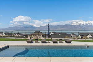 View of pool with fence, a fenced in pool, a mountain view, and a patio