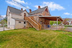 Rear view of property featuring a gate, a fenced backyard, and stucco siding