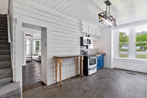 Kitchen with visible vents, baseboards, white cabinets, appliances with stainless steel finishes, and blue cabinetry