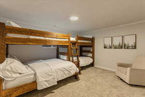 Bedroom with baseboards, ornamental molding, and carpet flooring