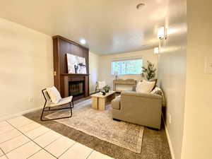 Living area featuring baseboards, tile patterned flooring, and a fireplace