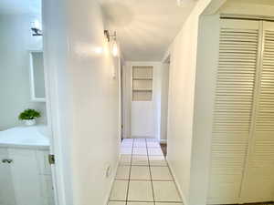Corridor featuring built in features and tile patterned flooring