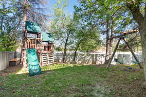 View of yard with a fenced backyard and a playground