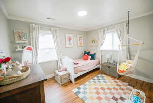 Bedroom with baseboards, visible vents, and ornamental molding
