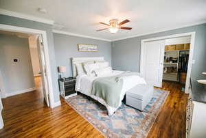 Bedroom with ornamental molding, a closet, and wood finished floors