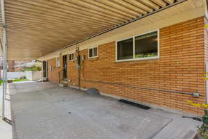 View of side of home with entry steps, fence, and brick siding
