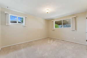 Empty room featuring carpet floors, baseboards, and visible vents