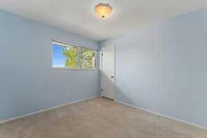 Spare room featuring baseboards, light colored carpet, and visible vents