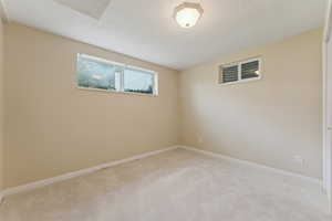 Spare room featuring baseboards and light carpet