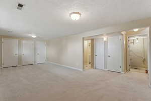 Unfurnished bedroom with multiple closets, baseboards, visible vents, and connected bathroom