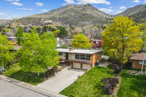 View of front of home with driveway, a mountain view, a front yard, and a garage