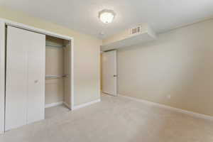 Unfurnished bedroom featuring a closet, carpet flooring, baseboards, and visible vents