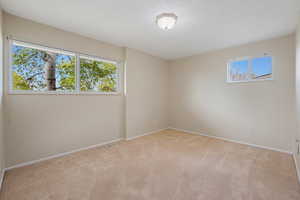 Carpeted empty room with baseboards and visible vents